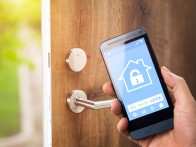 smart house, home automation, device with app icons. Man uses his smartphone with smarthome security app to unlock the door of his house.